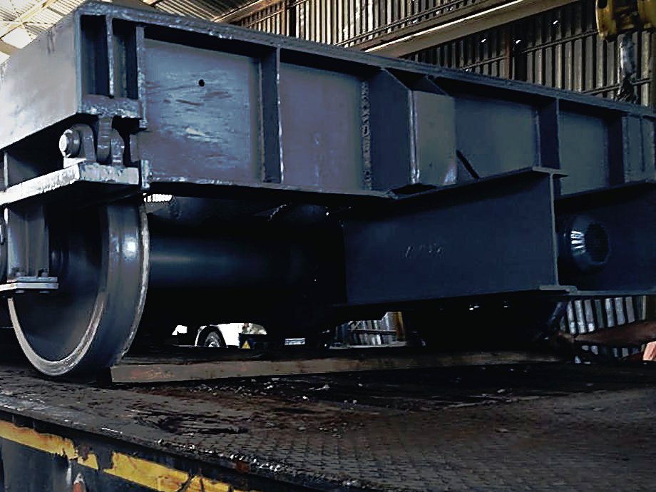 Heavy fabricated steel bogie frame with stiffened plate girders, loaded on a flatbed inside the Tripcon workshop
